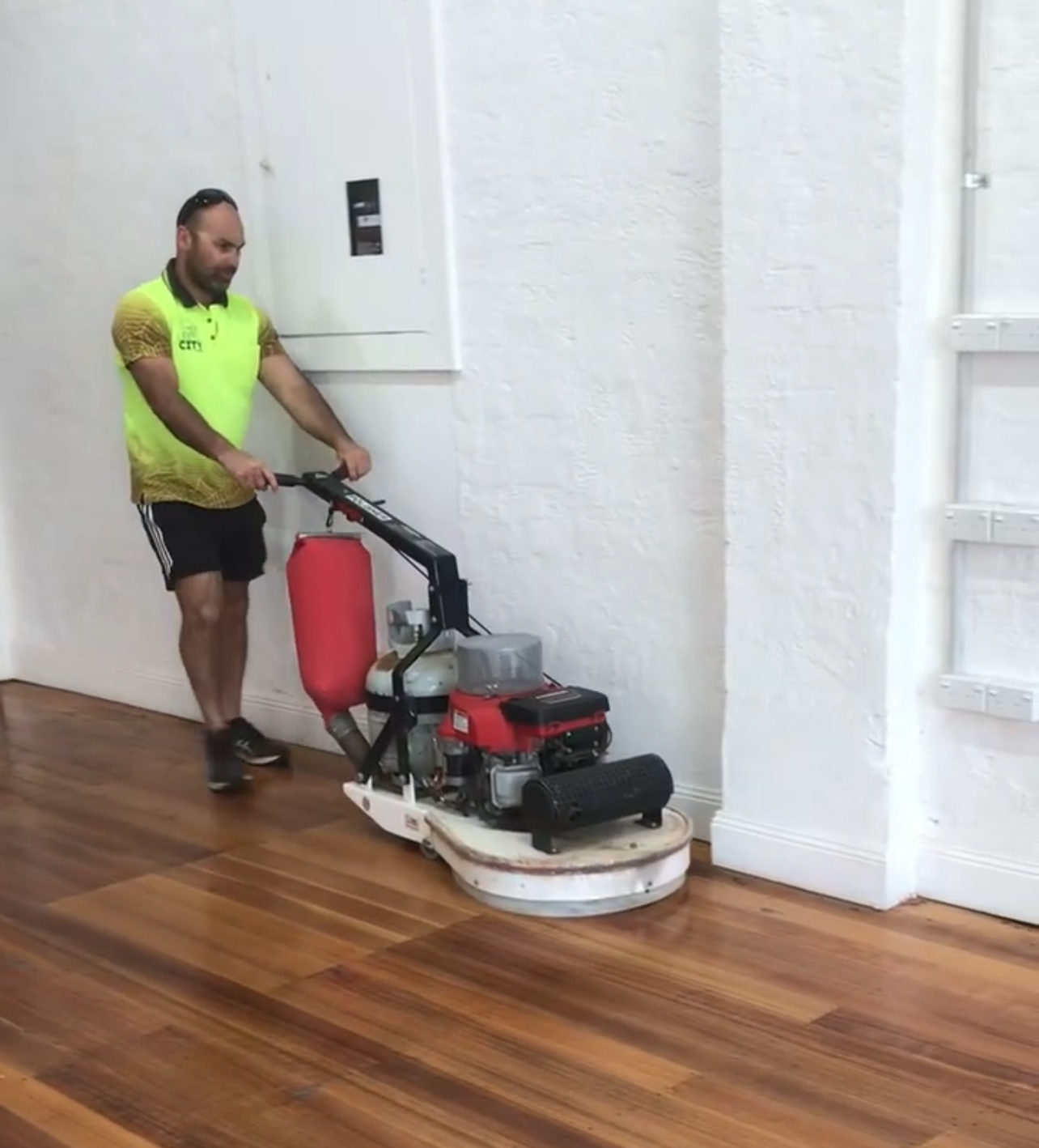 Sun City team polishing a hardwood floor with a rotary machine